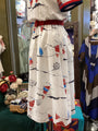 White dress with nautical patterns on a mannequin in a store setting.