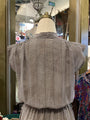 Mannequin wearing a black and white striped shirt with a blurred store interior in the background