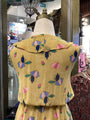 Mannequin wearing a yellow floral dress in a store setting