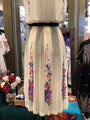 Mannequin wearing a floral embroidered dress in a store setting