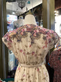 Floral dress on a mannequin with a blurred store interior background