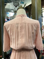 Pink blouse on a mannequin with a blurred store interior background
