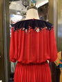 Red dress with floral embroidery on a mannequin in a store setting