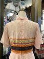 Mannequin wearing a patterned shirt with a store interior background