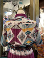 Mannequin wearing a colorful patterned dress in a store setting