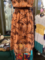 Brown floral dress on a mannequin with a blurred store background