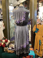 Mannequin wearing a gray dress with floral patterns in a store setting