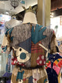 Mannequin wearing a colorful, patterned dress with abstract designs in a store setting.