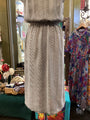 Striped dress on a mannequin in a store setting with colorful dresses in the background.