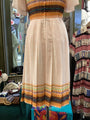 Beige dress with colorful patterns on a rack in a store setting