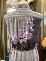 Mannequin wearing a gray blouse with floral patterns in a store setting