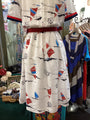 Dress with kite and sailboat pattern on a rack in a store setting