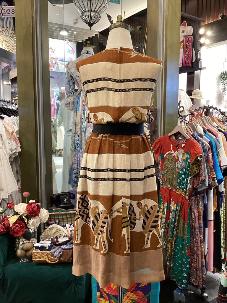 Mannequin wearing a patterned dress with animals in a store setting