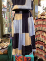 Colorful patterned dress hanging in a store with vintage clothing in the background