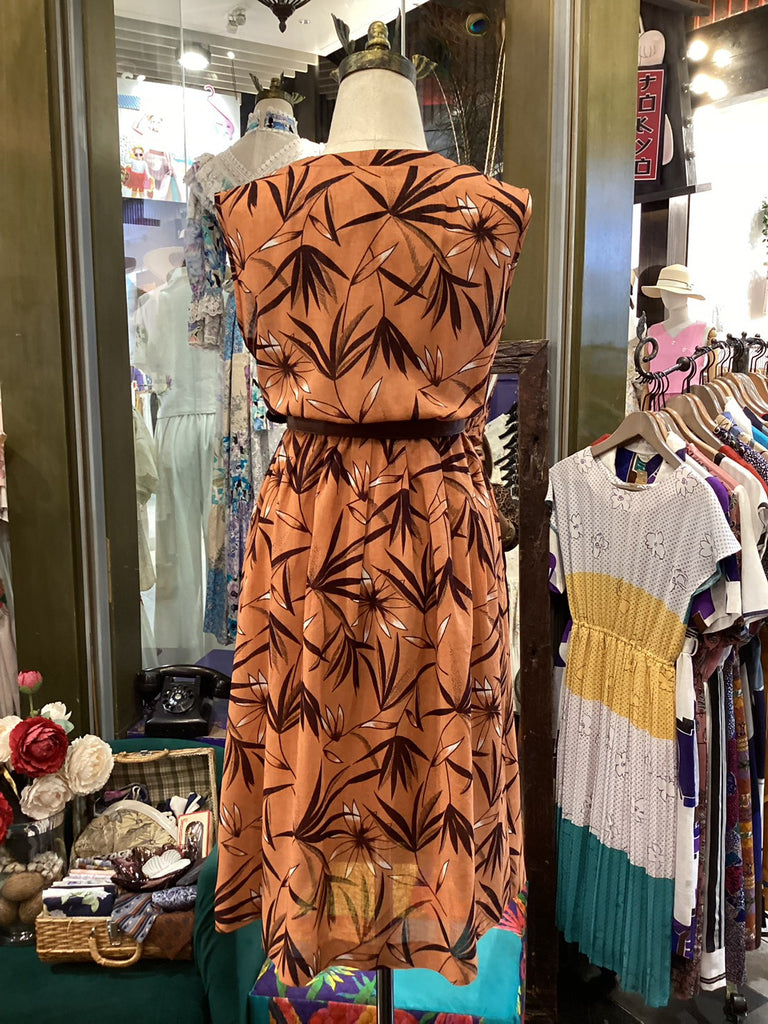 Brown dress with leaf pattern on a mannequin in a store setting